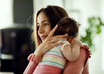 A single mother holding baby over the shoulder