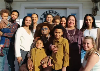 A large family standing at the front door of a house
