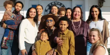 A large family standing at the front door of a house
