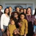 A large family standing at the front door of a house