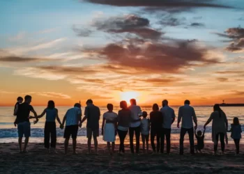 A large family watching the sunset at the beach