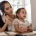 Mother and daughter using a computer and internet during mother working from home