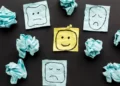 Pieces of paper with faces drawn on in various emotional states. Represents attitudes towards something.