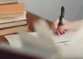 hand with pen writing a dissertation
